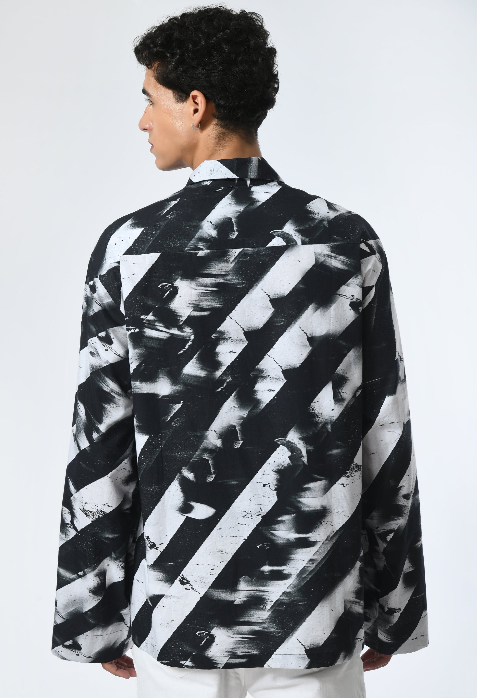 Man wearing a Binary Stripes Shirt with a black and white print inspired by the Bombay to Tokyo journey.